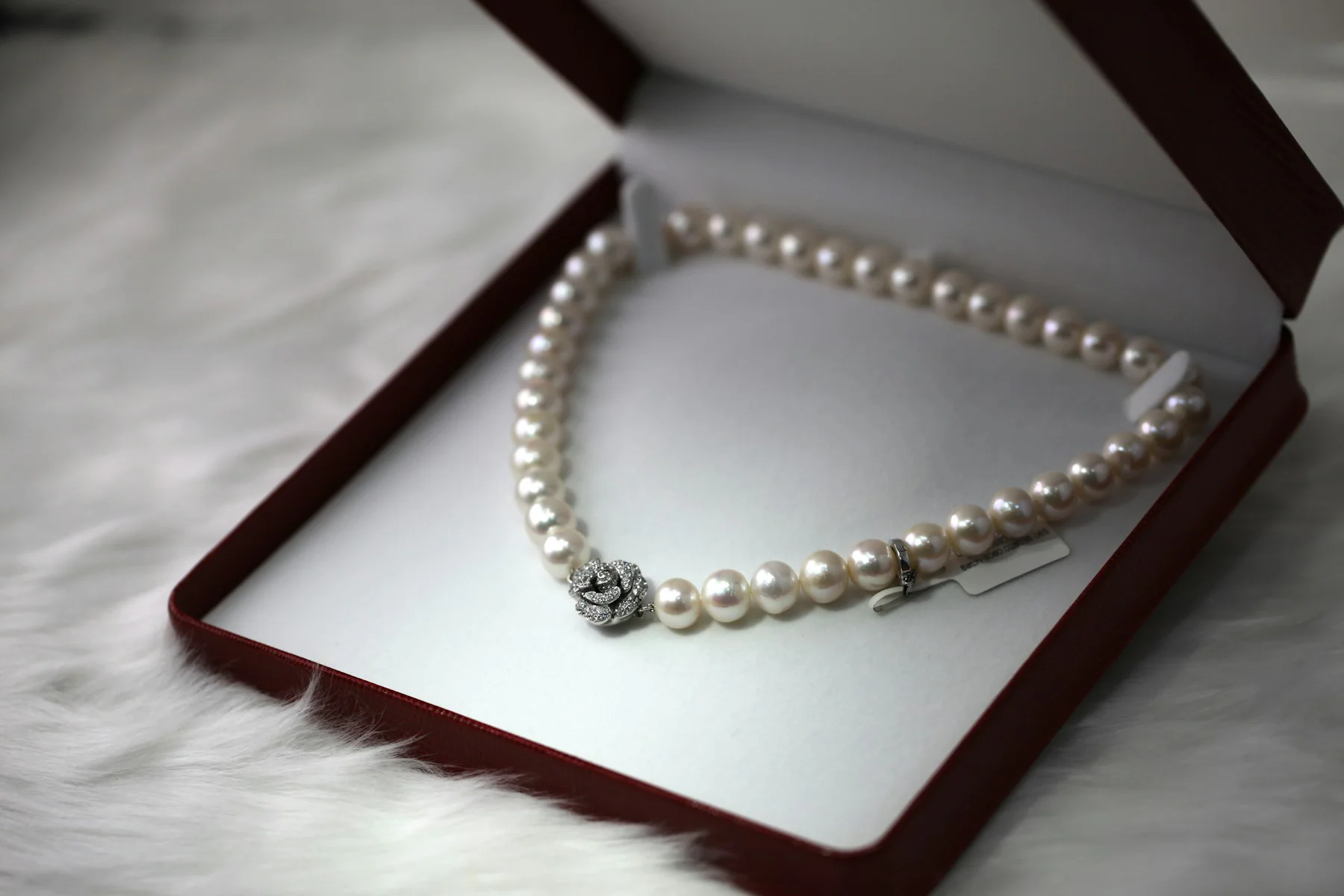 Pearl necklace in an open burgundy jewellery box