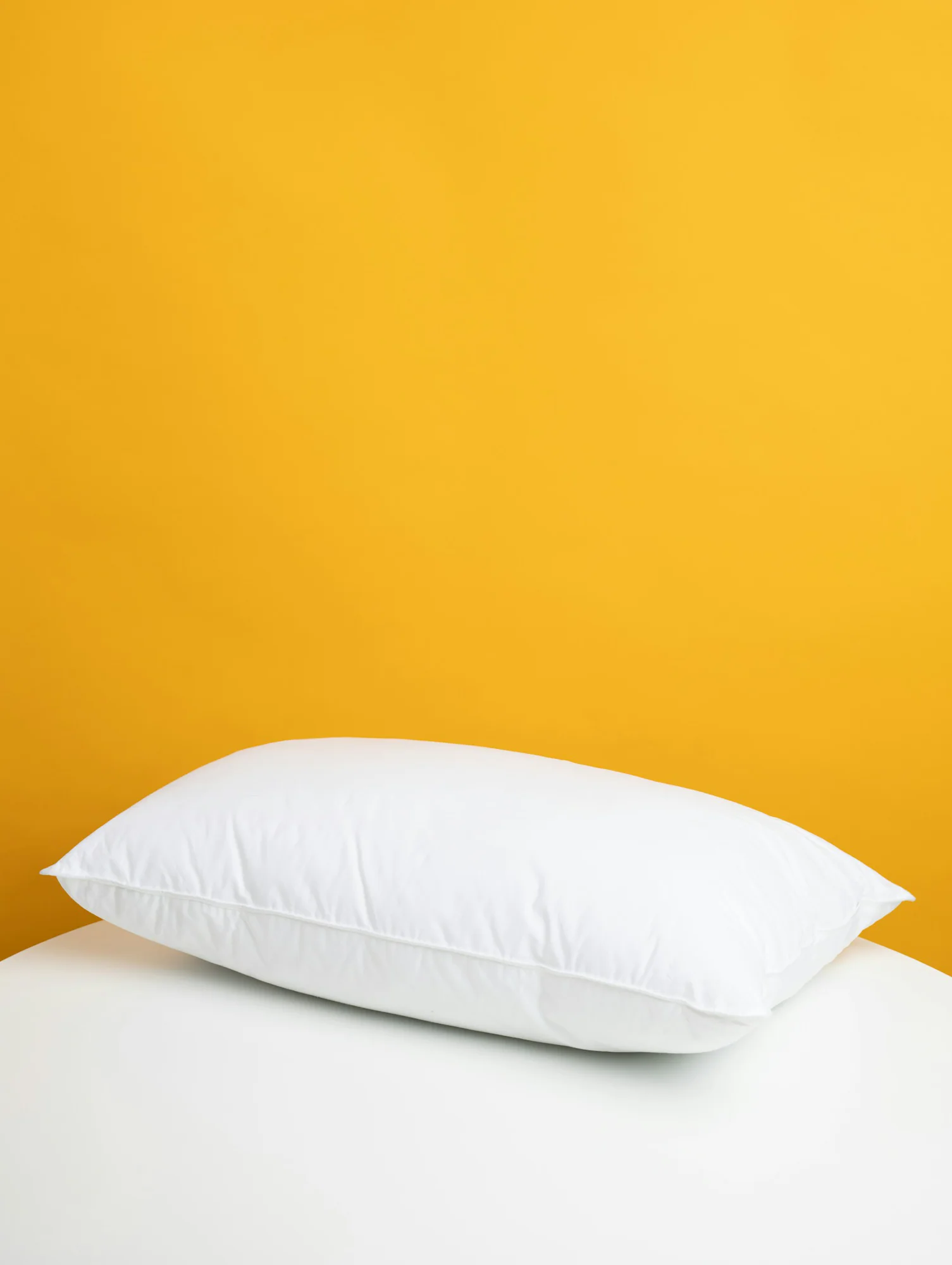 White pillow against a yellow background