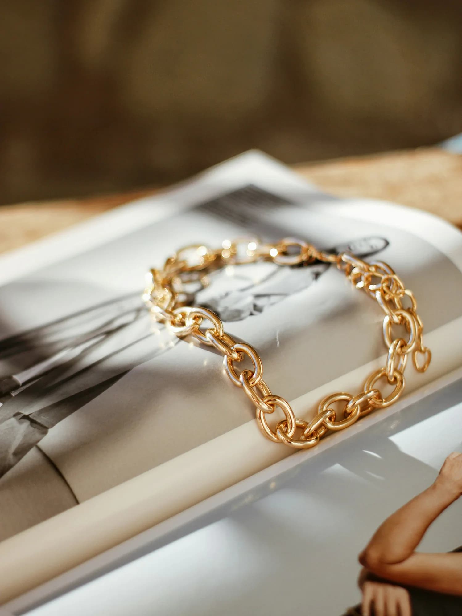 Gold curb chain bracelet on a book page