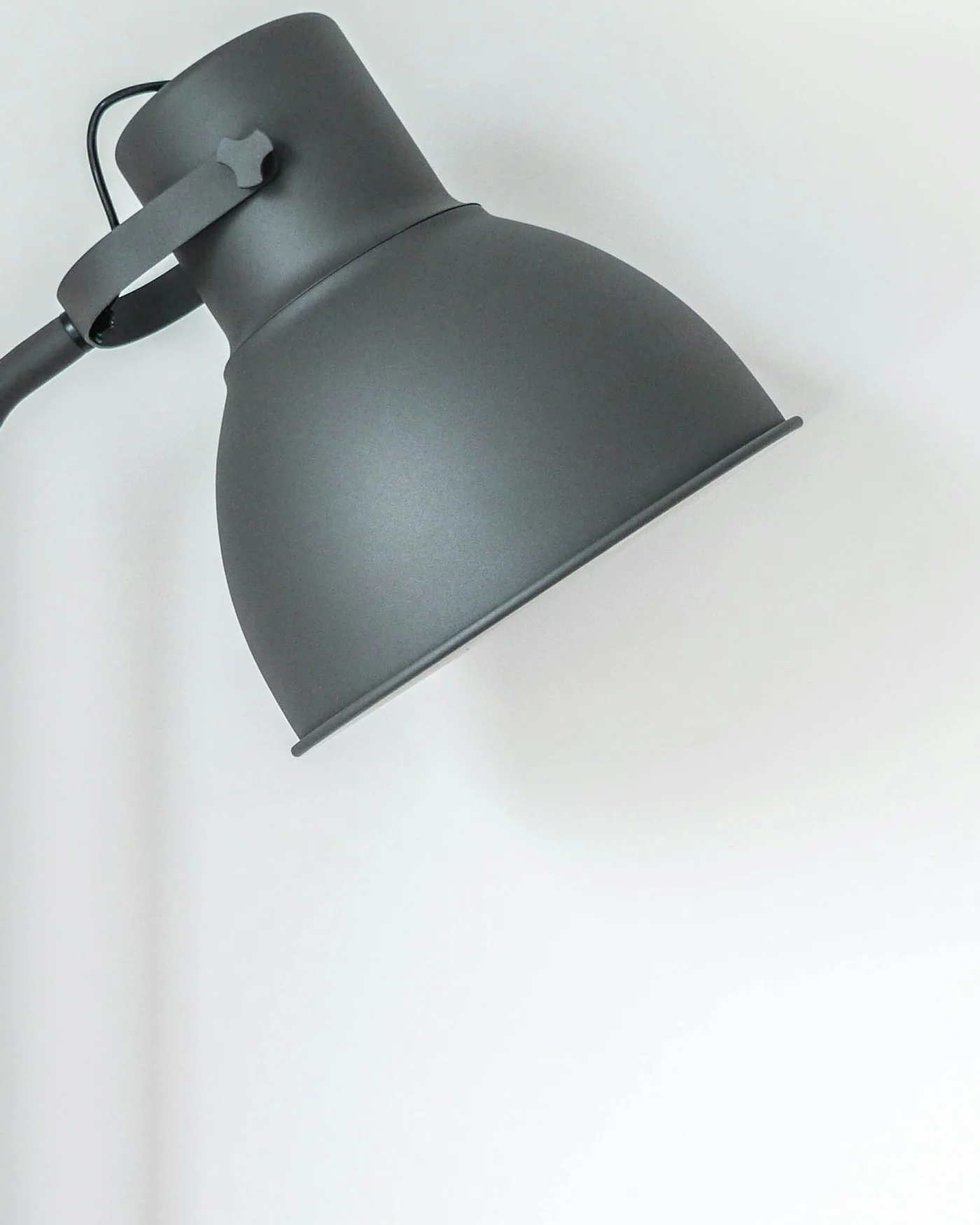 Grey floor lamp against a white wall — detail
