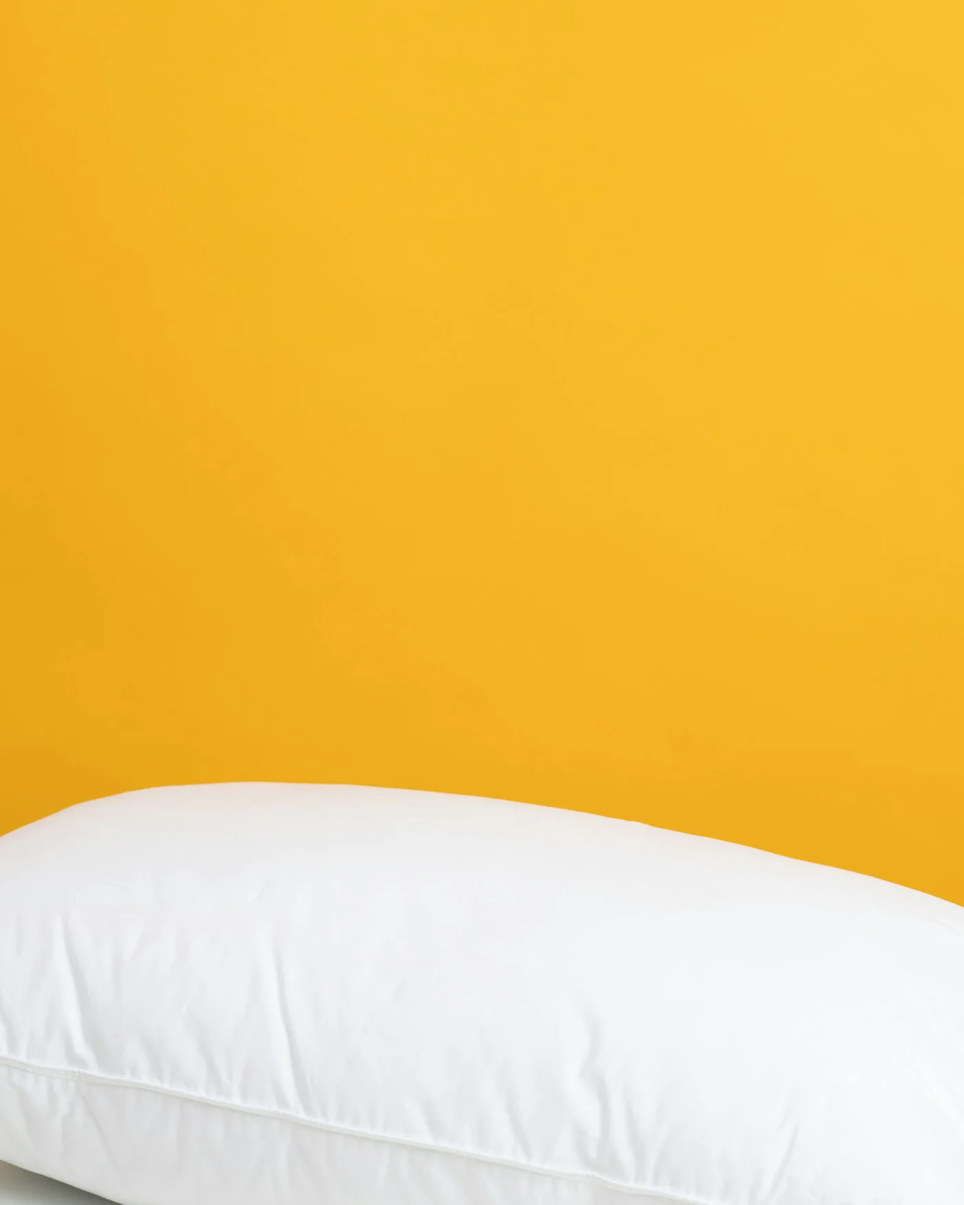 White pillow against a yellow background — detail