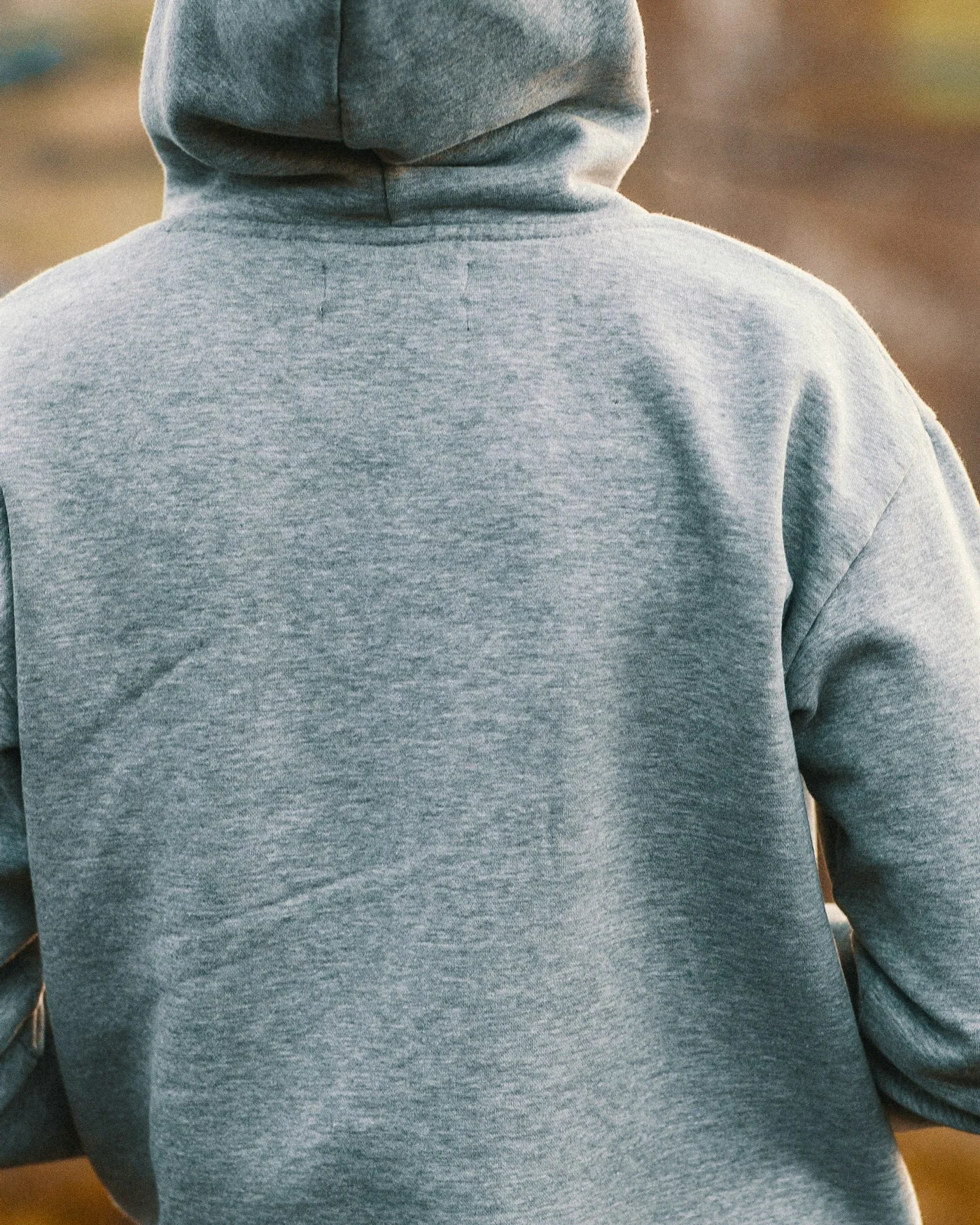 Person wearing a grey hoodie seen from behind — detail