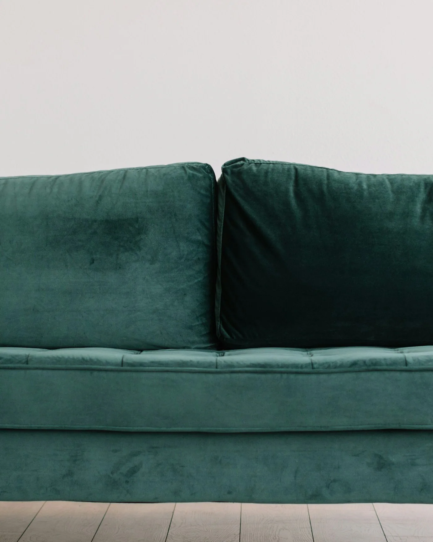Emerald green velvet sofa in a bright room — detail