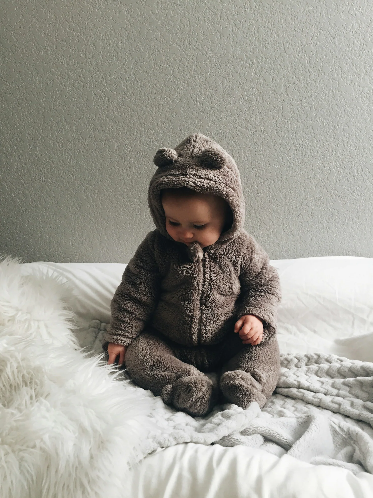 Baby wearing a brown bear-ear fleece onesie